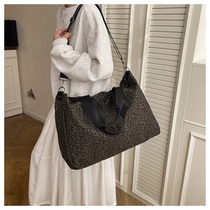 Dettaglio della borsa tote leopardata grande con tracolla e manici in nylon nero