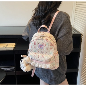Détail du mini sac à dos floral avec bretelles roses, dentelle blanche et charme peluche