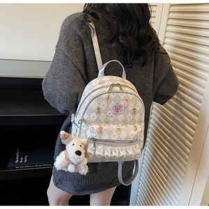Vue détaillée du sac à dos crème avec matelassage en losange et bordure en dentelle