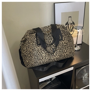 Dettaglio della borsa da viaggio leopardata con cinghie in nylon su scaffale