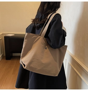 Primer plano del bolso tote grande caqui con tela texturizada y correa ancha al hombro