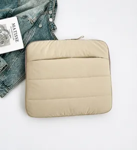 Detail view of khaki quilted laptop sleeve with horizontal padding and top zipper closure