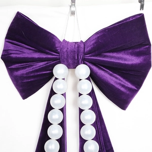 Large purple velvet bow wall hanging with elegant white pearls for festive party decoration