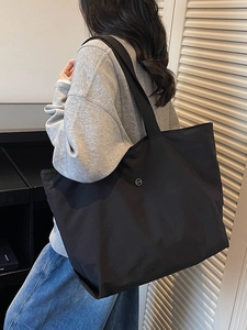 Bolso tote grande negro minimalista con logo metálico CM y correa ancha