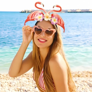 Detail of pink flamingo party headband featuring tropical flowers on a summer beach backdrop