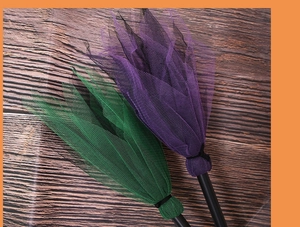 Détail des couches de tulle violet et vert sur le balai de sorcière en plastique