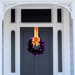 Halloween wreath with black and purple tinsel, orange pumpkin ribbon and festive bow