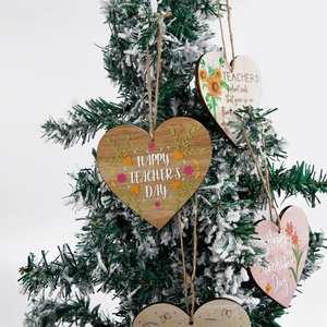 Wooden heart-shaped teacher appreciation ornaments with sunflowers hanging on a tree