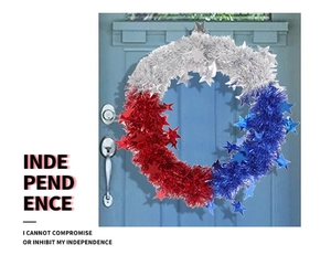 Detail of red white and blue Independence Day wreath with stars on a blue wooden door