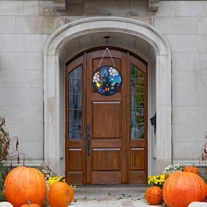 Halloween wooden round door plaque with glowing pumpkin and ghost on a dark wood door