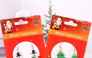 Vue détaillée de boucles d'oreilles bonhomme de neige sur carte de Noël rouge festive