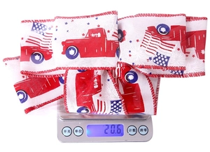 Close-up of Independence Day ribbon decoration with red truck and flag on a digital scale