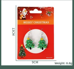 Details von Weihnachtsbaum-Ohrringen auf festlicher roter Verpackung mit Weihnachtsmann