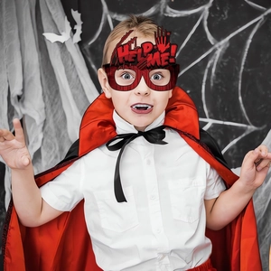 Detail of Halloween costume kit with red-black cape and HELP ME blood-effect glasses