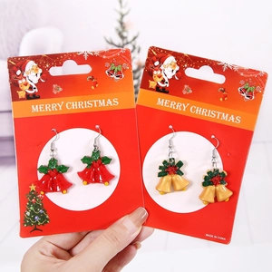 Boucles d'oreilles de Noël avec cloches festives et feuilles de houx sur support carte