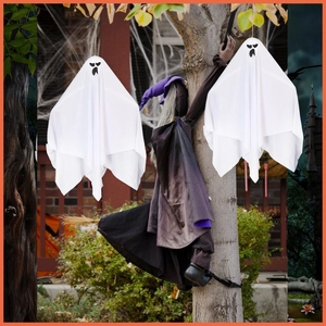 Outdoor Halloween set with white hanging ghosts and a witch crashing into a tree trunk