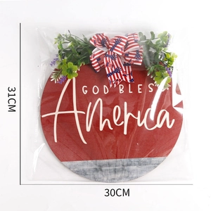 Close-up of God Bless America wooden door sign with red-blue bow and greenery detail