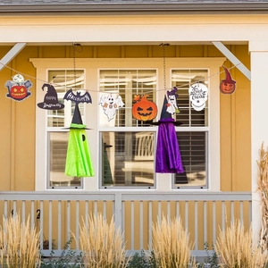 Outdoor porch decor with Halloween hanging ornaments of pumpkins, ghosts and wooden banners