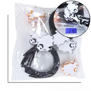 Detail of Halloween ghost and pumpkin headbands showing product weight on a scale