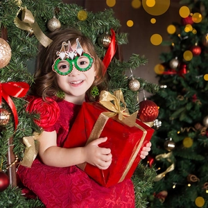 Girl wearing festive Christmas gnome glasses featuring red and green holiday decor