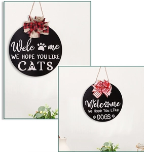 Detail van ronde houten deurborden met zwarte afwerking, witte letters en decoratieve strik