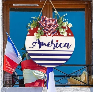 Detail of round wooden America wall sign with red white blue bow and eucalyptus leaves