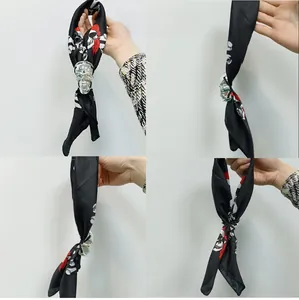 Détail d'un foulard noir à tête de mort avec une boucle argentée pour costumes d'Halloween