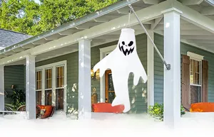 Ghost windsock decoration hanging on a wooden porch for outdoor Halloween courtyard decor