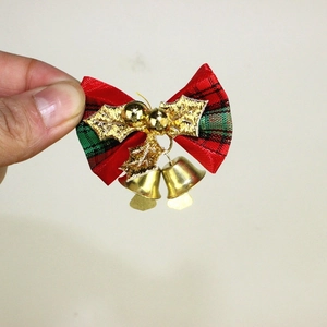 Detail einer Weihnachtsschleife mit goldenen Stechpalmenblättern und Glocken