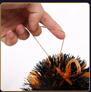 Close-up of Halloween garland featuring black and orange pom poms with pumpkin sequins