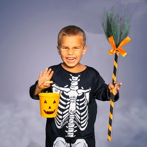 Détail d'un balai de sorcière d'Halloween avec nœud orange et filet vert décoratif