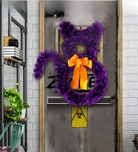 Macro shot of a purple cat-shaped tinsel wreath with an orange bow for Halloween decor