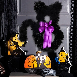 Close-up of black cat rattan wreath with purple bow and glowing LED Halloween wooden plaques