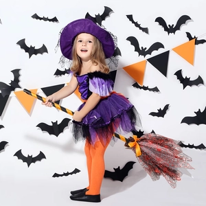 Détail d'une fille en costume de sorcière violet avec chapeau en tulle et balai