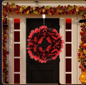 Detail of Halloween wreath with red pumpkin sequins and black fringe on a door