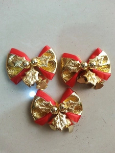 Detailsicht auf rote und goldene Weihnachtsschleifen mit Glöckchen und Stechpalmenblättern