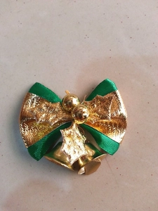 Detailansicht der Weihnachtsbaum-Schleife mit goldenen Glocken und Stechpalmen-Blättern