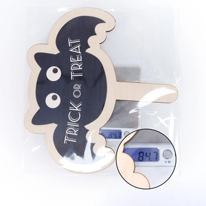 Detail view of a Halloween bat wooden sign on a digital scale showing 84.7g weight