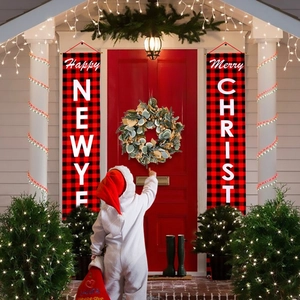 Detail von rot-schwarzen Karo-Weihnachtsbannern mit künstlichem grünen Kranz an der Tür