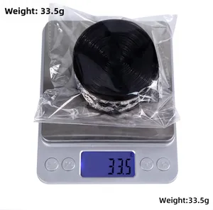 Detail showing 10m roll of black lace ribbon with white floral pattern on a scale