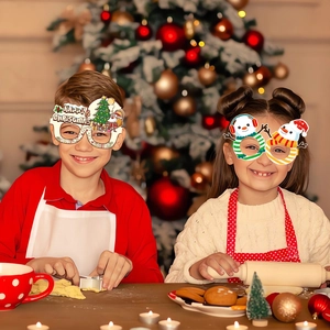 Niños con gafas de papel festivas para fiesta de Navidad con diseños de Santa