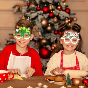 Close-up of children wearing festive Christmas tree and Merry Christmas paper glasses