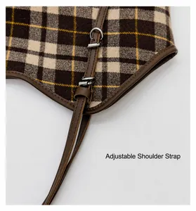 Détail d'une bandoulière en cuir réglable sur un sac cabas marron à motif à carreaux