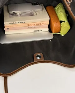 Vue de dessus de l'intérieur spacieux du cabas marron avec fermeture magnétique et objets