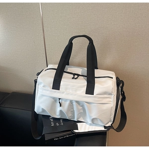 Nahaufnahme der weißen Segeltuch-Reisetasche mit schwarzen Trägern auf schwarzem Leder