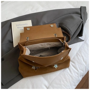 Detail view of brown matte backpack showing striped lining and star embroidery