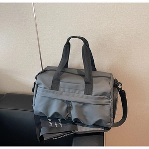 Detail der grauen wasserdichten Nylon-Reisetasche mit schwarzen Griffen und Schultergurt