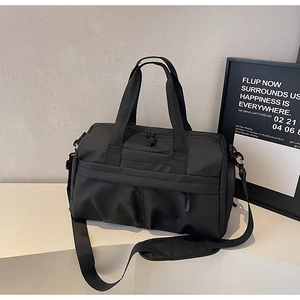Detail der schwarzen Reisetasche aus Canvas mit gepolstertem Schultergurt und Tragegriffen
