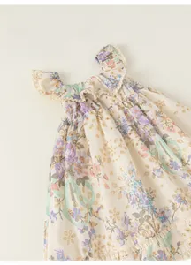 Gros plan sur l'imprimé fleuri et la broderie anglaise d'une robe de fille style français