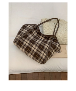 Detail van bruin geruite wollen shopper met smalle leren riemen op een witte achtergrond